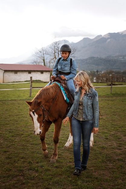 無料写真 子供に馬の乗り方を教える女性馬術インストラクター