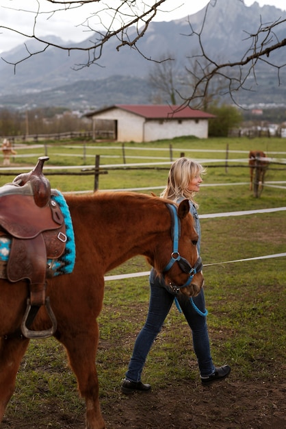 Foto gratuita istruttore equestre femminile con cavallo