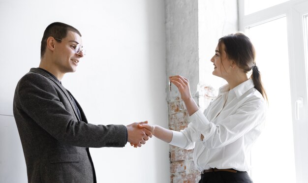 Female estate agent showing new home to a young man after a discussion on house plans moving new home concept