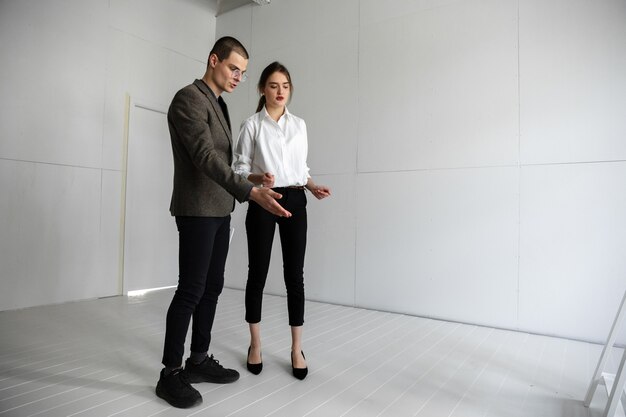 Female estate agent showing new home to a young man after a discussion on house plans moving new home concept