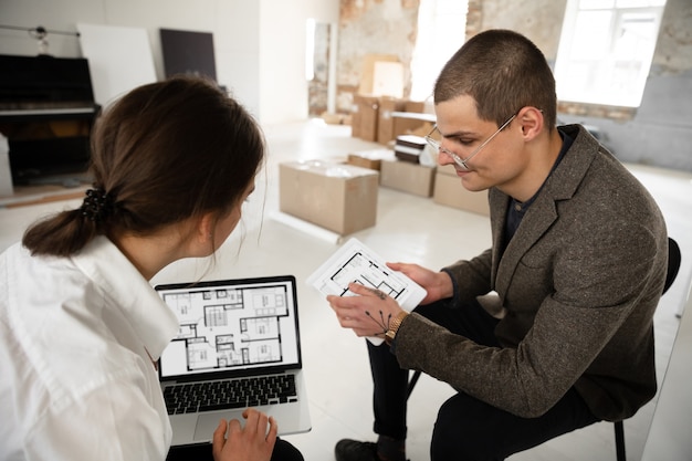 Free photo female estate agent showing new home to a young man after a discussion on house plans, moving, new home concept