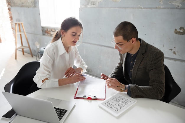 Female estate agent showing new home to a young man after a discussion on house plans.