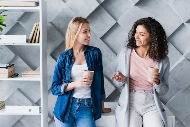 Foto gratuita impiegati di ufficio etnici femminili all'intervallo per il caffè