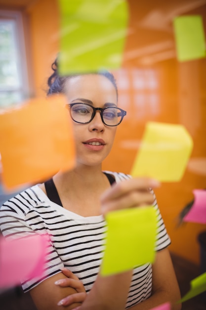 Free photo female executive reading sticky notes