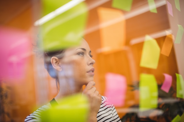 Female executive reading sticky notes