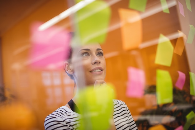 Free photo female executive reading sticky notes