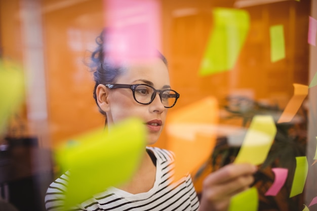 Free photo female executive reading sticky notes