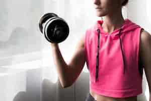 Free photo female exercising with dumbbell at home