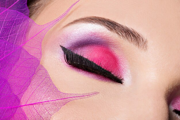 美しいファッションの明るいピンクのメイクで女性の目