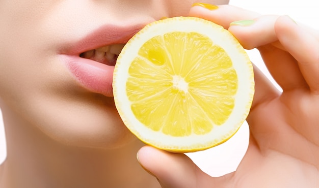 여성의 얼굴과 레몬의 절반을 닫습니다.