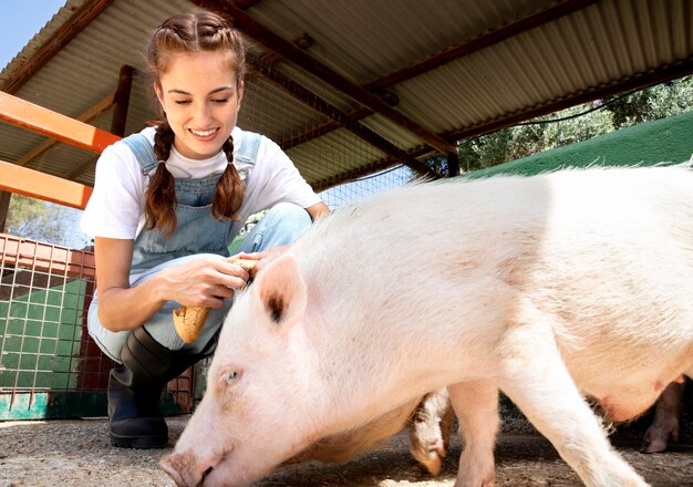 Женщина-фермер кормит свиней