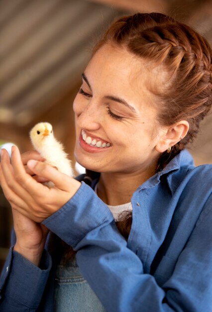 Female farmer holding a baby chicken