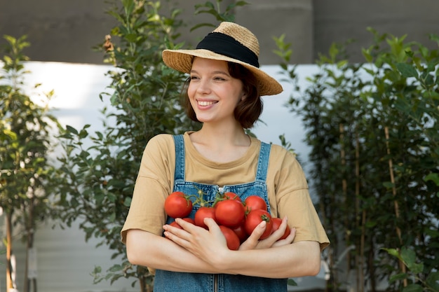 Free photo female farmer holding some tomatoes