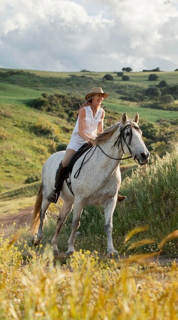 Female farmer horseback riding in nature outdoors