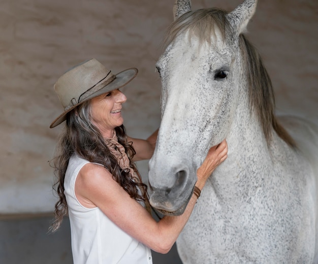 Foto gratuita coltivatore femminile con il suo cavallo