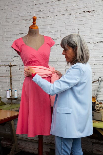 服に取り組んでいるスタジオの女性ファッション デザイナー
