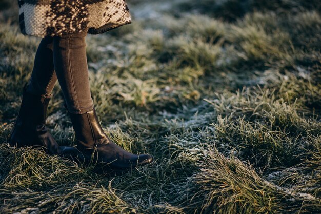 Female feet on the grass covered with hoarfrost