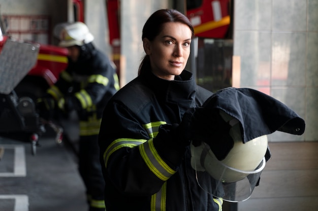 Free photo female firefighter putting on safety helmet