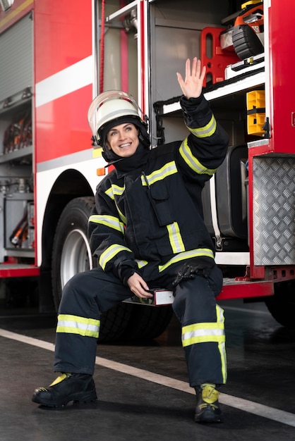 Женщина-пожарный на станции в костюме и защитной каске