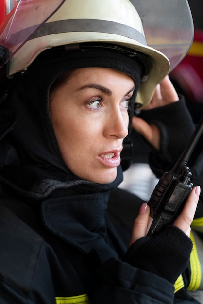 Female firefighter at station equipped with suit and safety helmet