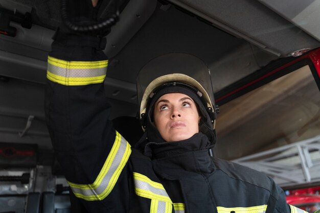 Female firefighter at station equipped with suit and safety helmet