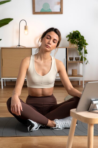 Female fitness instructor teaching an online class from home using a tablet