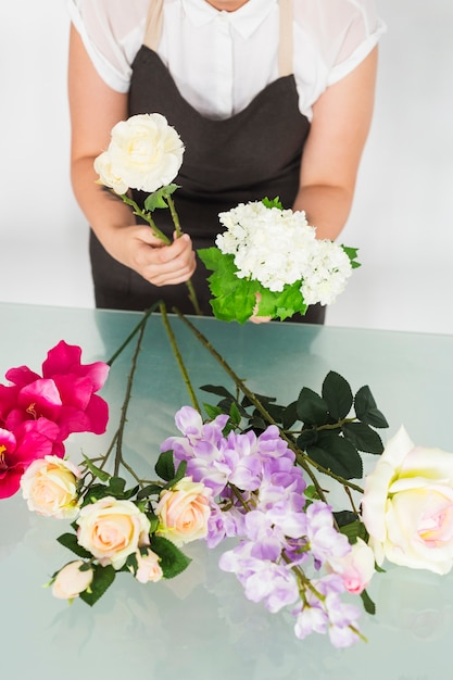 白い花を持つ女性の花屋の手