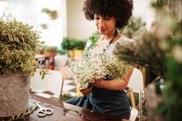 Female florist holding bunch of beautiful white flowers