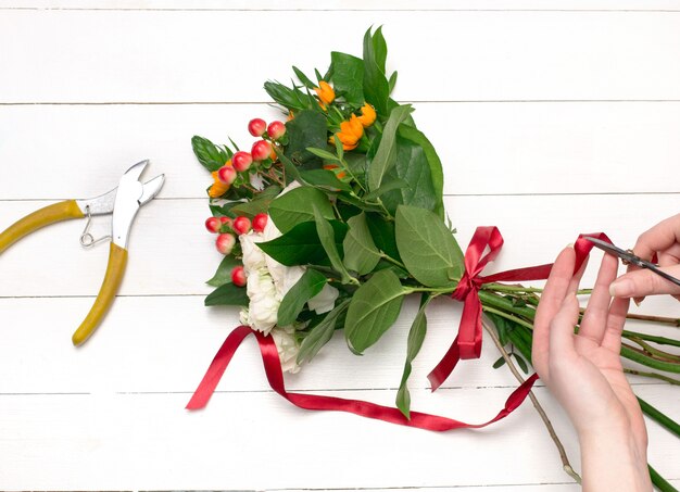 Foto gratuita fiorista femminile che fa bello mazzo al negozio di fiore