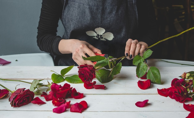 Free photo female florist making a bouquet of roses