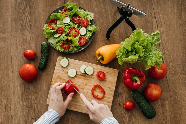 Female food blogger streaming at home while cooking with smartphone