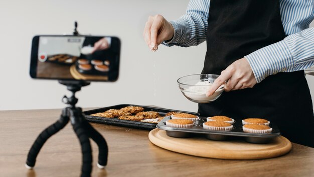 Female food blogger streaming at home with smartphone while cooking