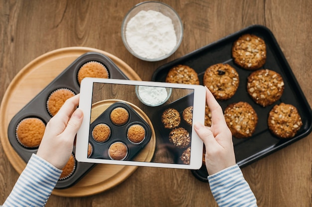 Blogger di cibo femminile in streaming con tablet a casa durante la cottura