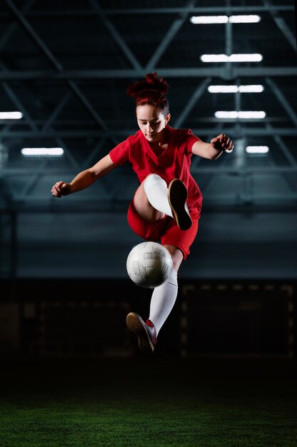 Female football player kicking ball