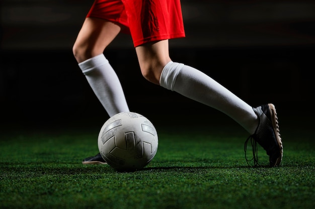 Free photo female football player running next to ball