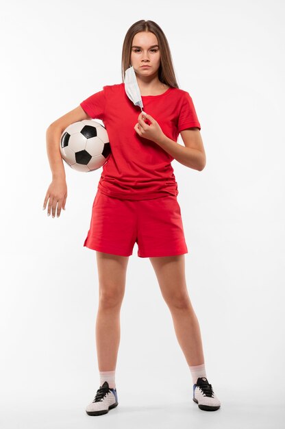 Female football player with mask holding ball