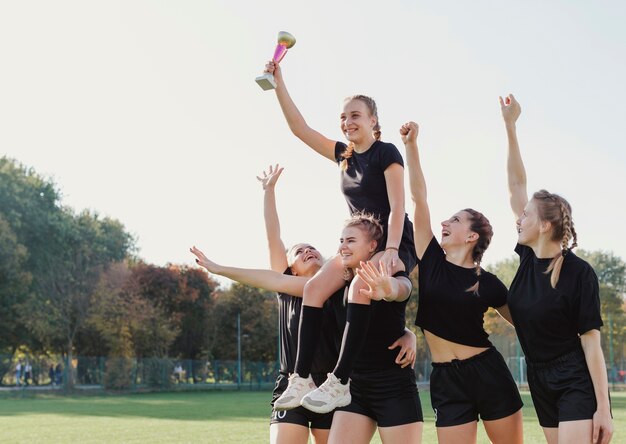 女子サッカー選手がトロフィーを獲得