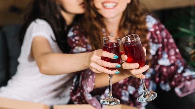 Female friend's hand toasting glasses