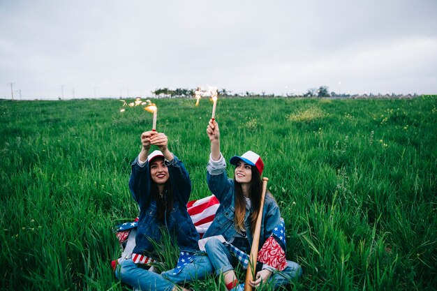 Female friends celebrating Independence Day on green grass