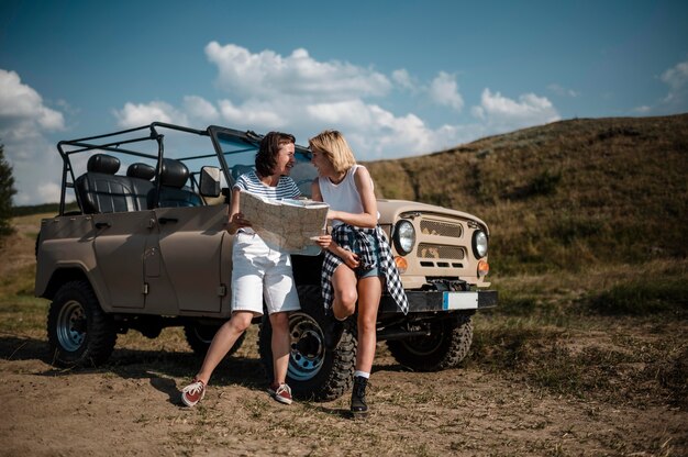 Female friends checking map while traveling by car