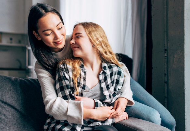 Female friends embracing at home