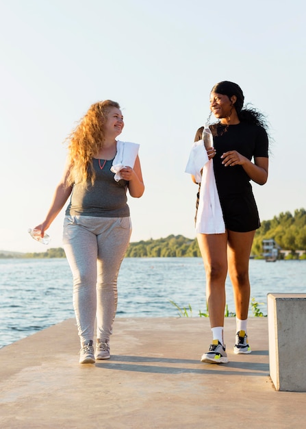 Female friends exercising by the lake together