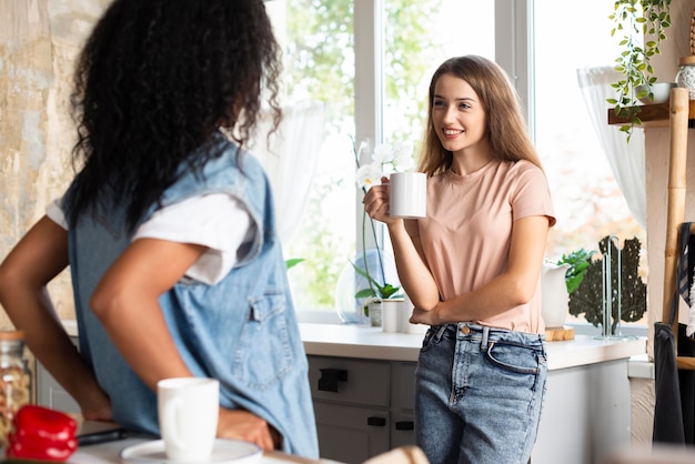 female friends having a conversation in the kitchen over coffee