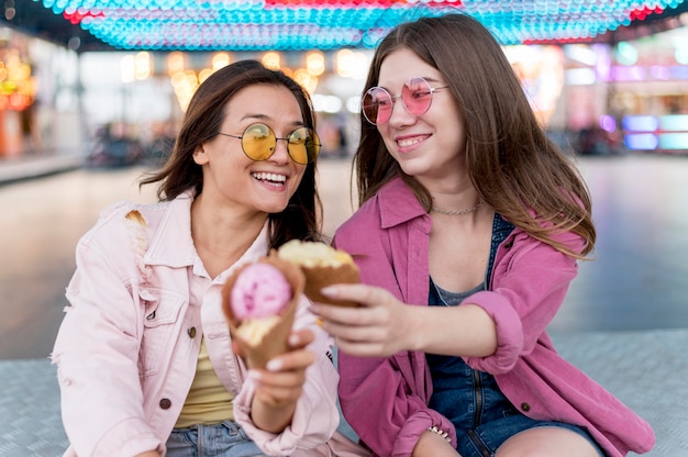 Foto gratuita amici femminili che mangiano cibo al parco di divertimenti