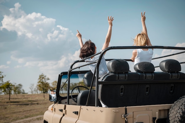 Foto gratuita amici femminili che hanno divertimento viaggiando in auto