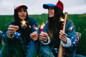 Foto gratuita amici femminili divertendosi con le luci del bengala