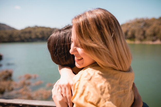 川の近くを抱き合っている女性の友達