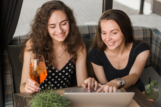 Женские друзья, глядя на ноутбук в ресторане