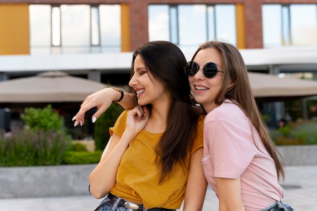 Foto gratuita amiche all'aperto in città che posano insieme