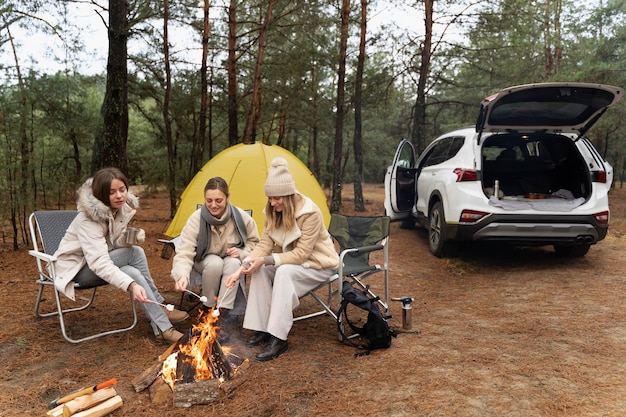 Free photo female friends roasting marshmallows using a bonfire